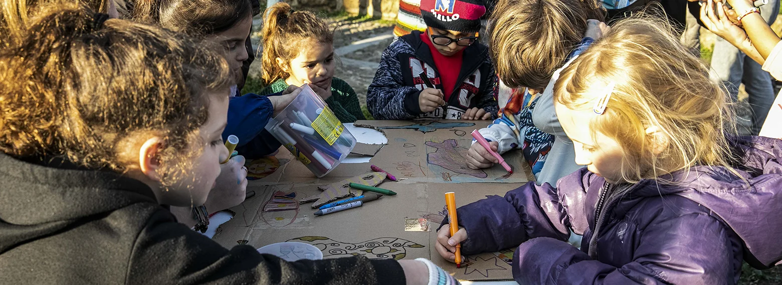 Bambini disegnano insieme in cerchio