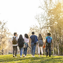 Studenti di spalle che camminano nel parco