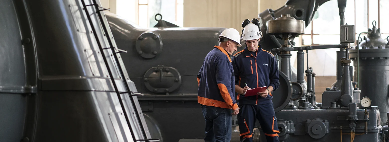 due tecnici parlano in una sala macchinari